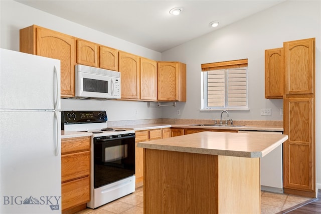 kitchen with a center island, sink, light tile patterned floors, and white appliances