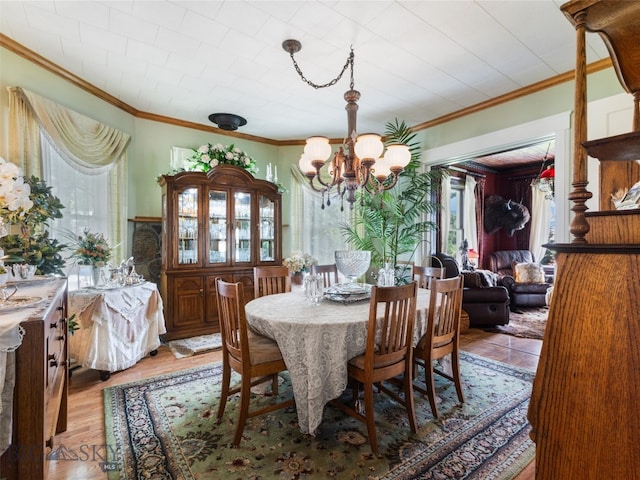 dining room with crown molding, hardwood / wood-style floors, and an inviting chandelier