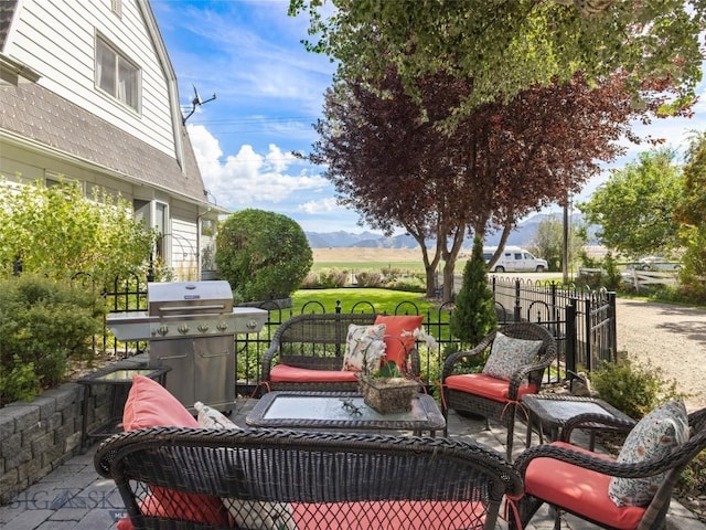 view of patio / terrace featuring fence, a mountain view, and area for grilling