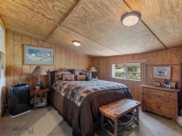 bedroom with lofted ceiling, wooden ceiling, wooden walls, and carpet