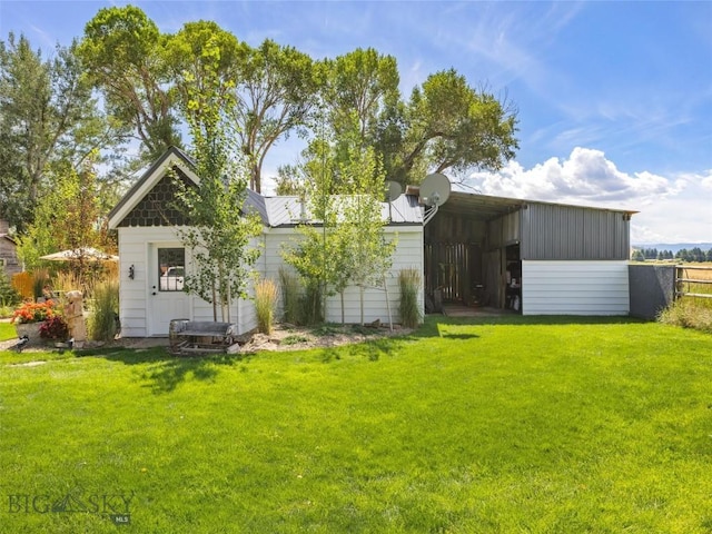 back of property featuring fence, a carport, and a yard