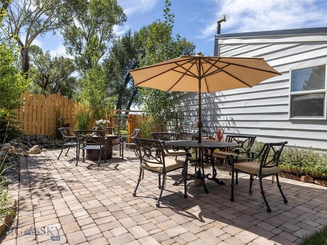 view of patio featuring outdoor dining space and fence