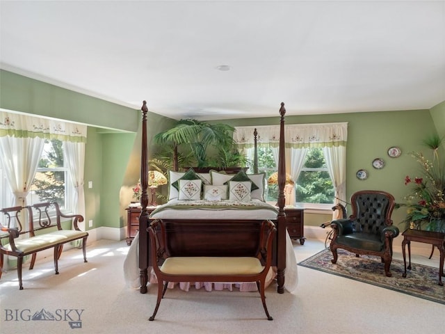 bedroom featuring light carpet, baseboards, and multiple windows