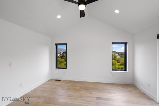 unfurnished room with ceiling fan, vaulted ceiling, and light hardwood / wood-style flooring