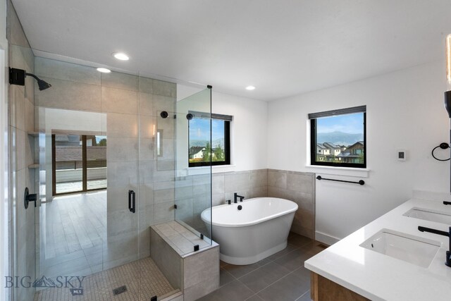 bathroom with independent shower and bath, tile patterned floors, a wealth of natural light, and vanity