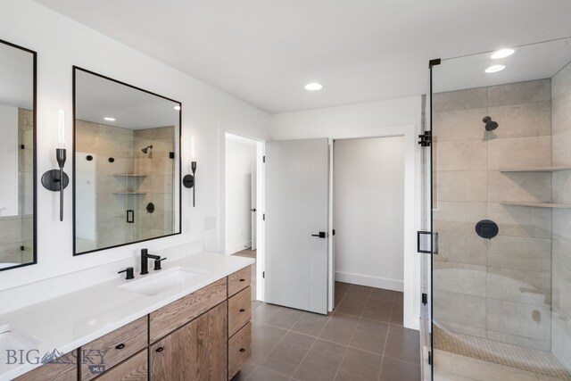 bathroom with tile patterned flooring, walk in shower, and vanity