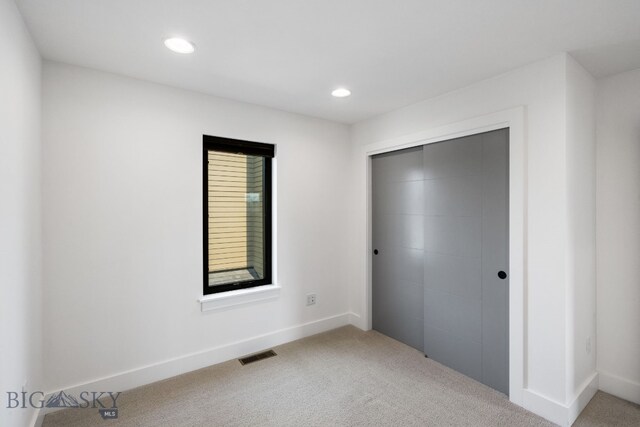 unfurnished bedroom featuring a closet and light carpet