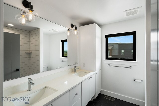 bathroom featuring vanity, a wealth of natural light, tile patterned floors, and toilet