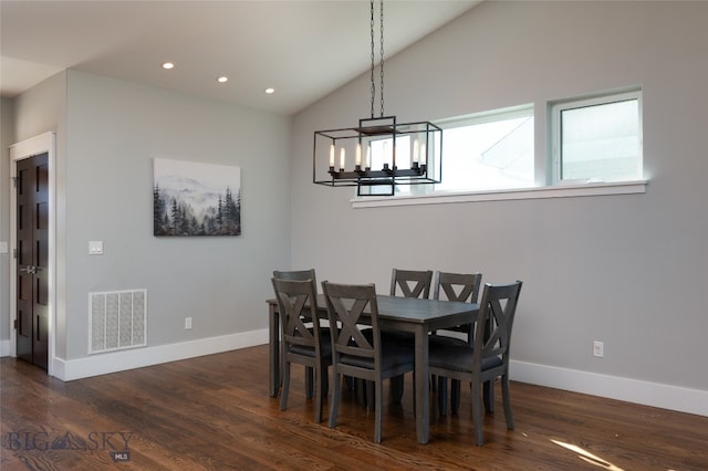 dining room featuring dark wood-type flooring, lofted ceiling, and an inviting chandelier