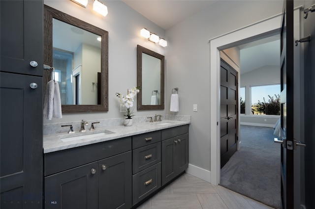 bathroom featuring vanity, vaulted ceiling, and tile patterned floors