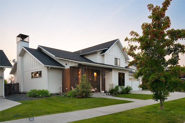 modern farmhouse featuring a lawn and a garage