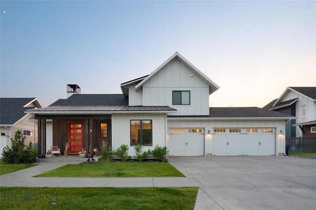 modern farmhouse with a garage and a lawn