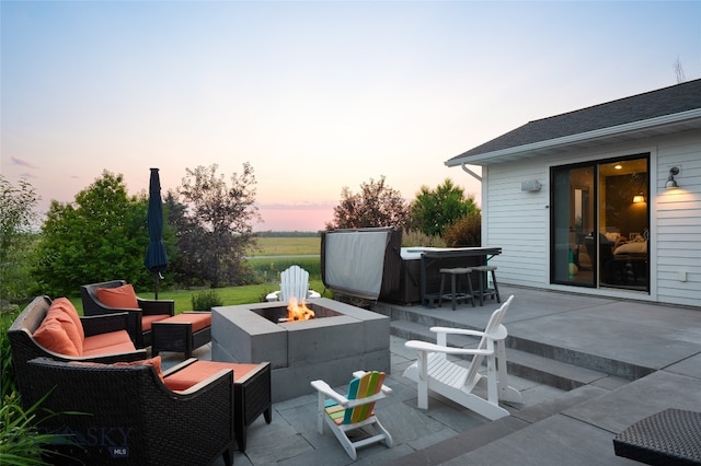 patio terrace at dusk with an outdoor living space with a fire pit