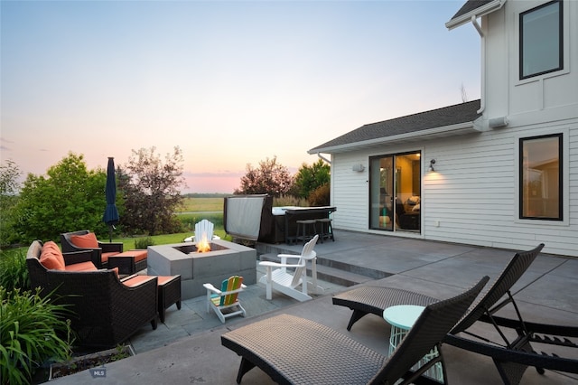 patio terrace at dusk with an outdoor living space with a fire pit