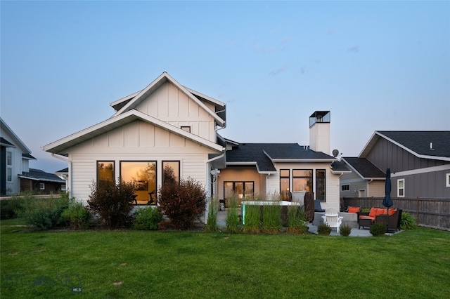 rear view of house featuring a yard and an outdoor living space