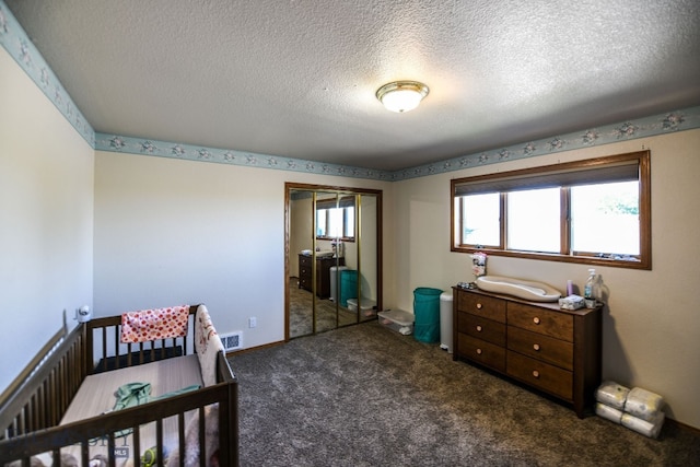 carpeted bedroom with multiple windows, a closet, and a textured ceiling