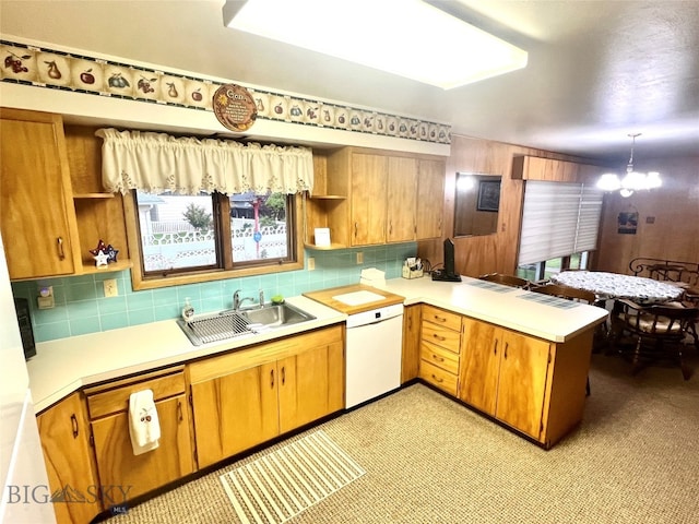 kitchen featuring decorative light fixtures, dishwasher, a notable chandelier, tasteful backsplash, and sink