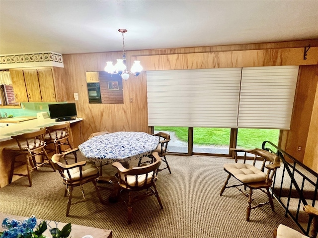 carpeted dining area featuring a chandelier