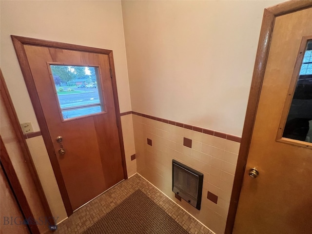 doorway to outside featuring tile walls and a fireplace