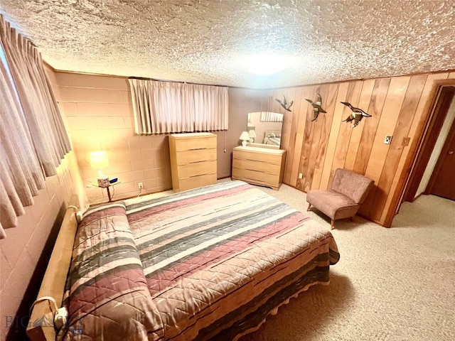 bedroom featuring a textured ceiling, carpet flooring, and wood walls