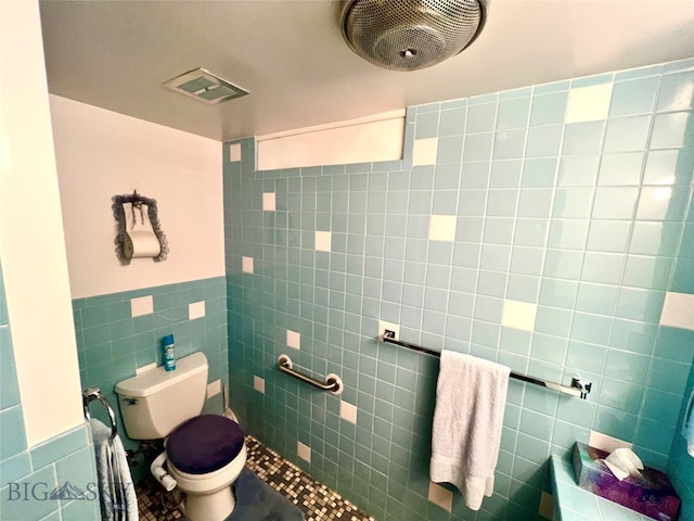 bathroom with tile walls and toilet