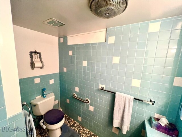 805 E Orr St, Dillon, MT 59725 - bathroom with tile patterned flooring, tile walls, toilet, a wainscoted wall, and visible vents