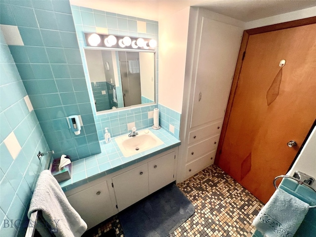 bathroom featuring tile patterned flooring, vanity, tile walls, and backsplash