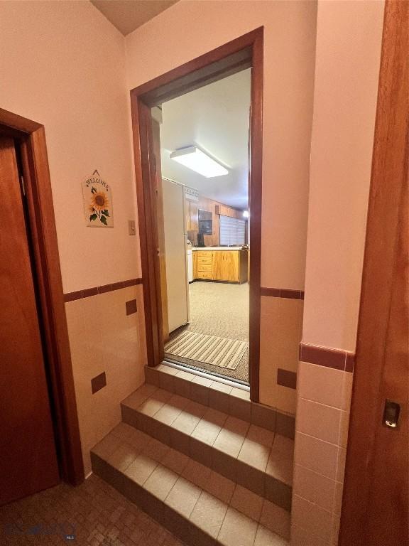 805 E Orr St, Dillon, MT 59725 - hallway with tile walls, tile patterned floors, and wainscoting