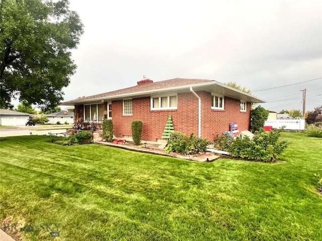 805 E Orr St, Dillon, MT 59725 - view of front of house featuring brick siding, a chimney, and a front lawn