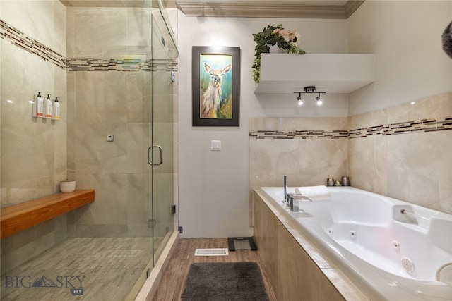 bathroom with independent shower and bath and wood-type flooring