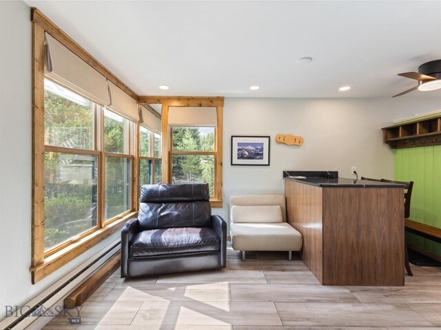 interior space with plenty of natural light, ceiling fan, and a baseboard radiator