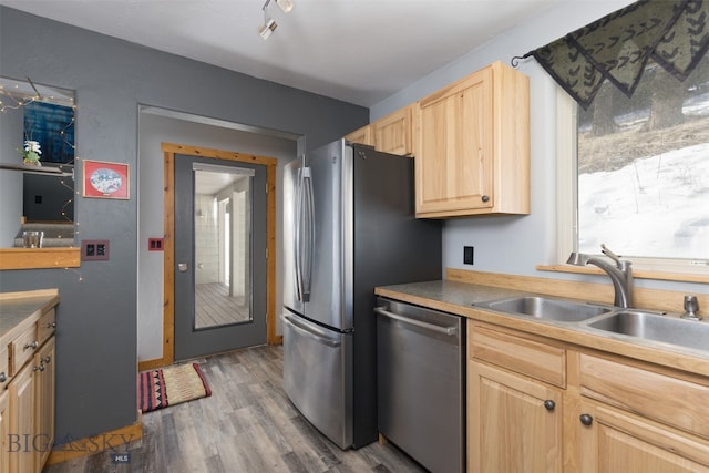 kitchen featuring stainless steel appliances, sink, hardwood / wood-style flooring, and light brown cabinetry