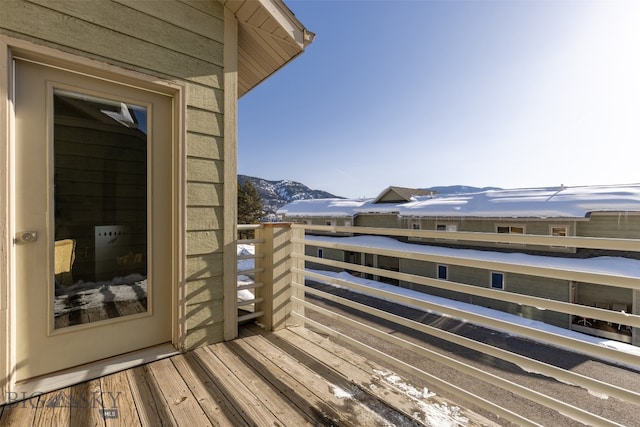 snow covered back of property featuring a mountain view