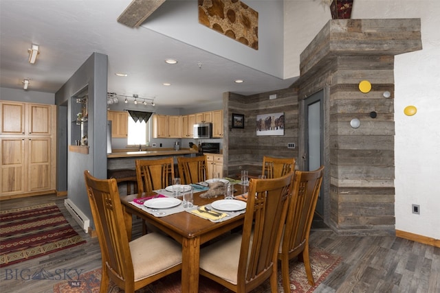 dining room with dark hardwood / wood-style floors and wooden walls