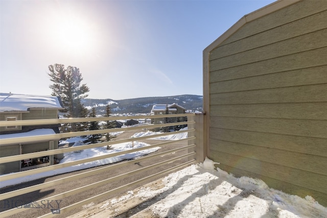 snow covered deck with a mountain view