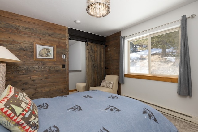 carpeted bedroom featuring a barn door and an inviting chandelier