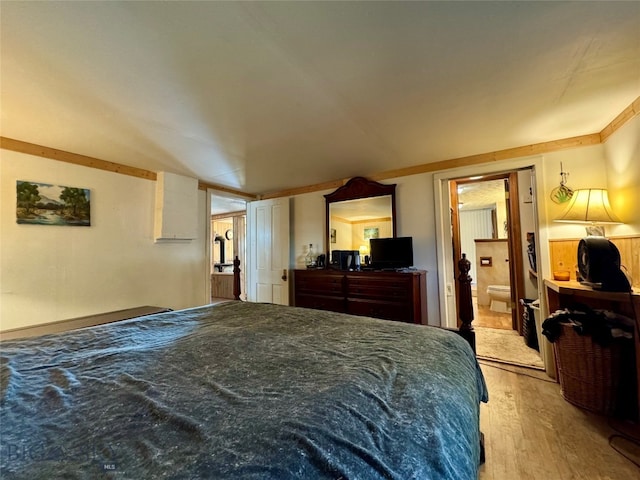 bedroom with ensuite bathroom and light wood-type flooring