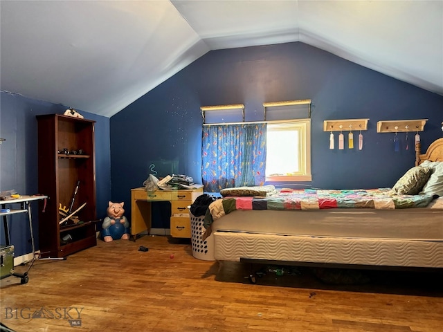 bedroom with hardwood / wood-style floors and vaulted ceiling