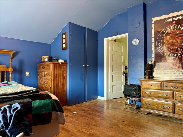 bedroom featuring hardwood / wood-style flooring and lofted ceiling