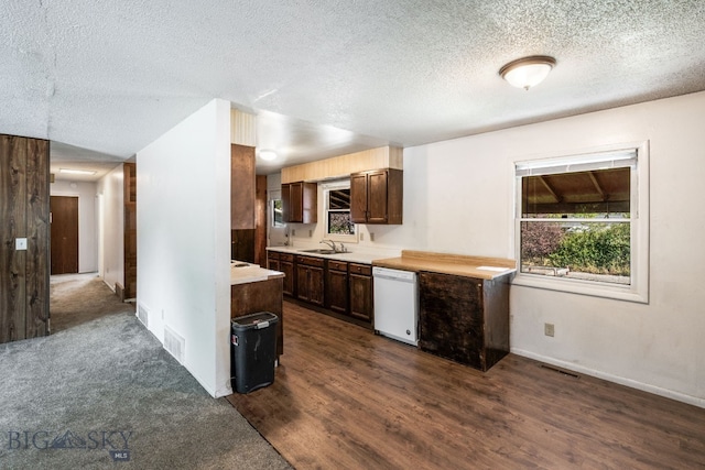 kitchen with white dishwasher, light countertops, a textured ceiling, and visible vents