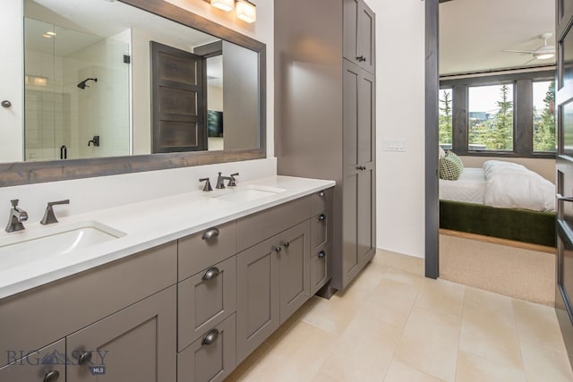 bathroom with a shower with door, vanity, ceiling fan, and tile patterned flooring