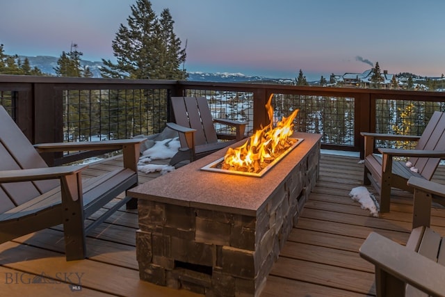 deck at dusk featuring an outdoor fire pit