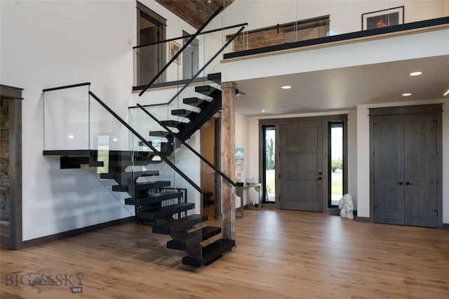 foyer entrance with hardwood / wood-style flooring and a towering ceiling