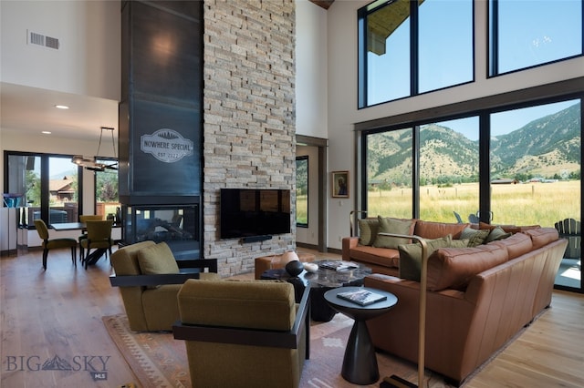 living room with a fireplace, a towering ceiling, and plenty of natural light