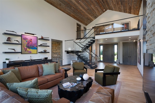 living room featuring sink, wood ceiling, light hardwood / wood-style flooring, and high vaulted ceiling