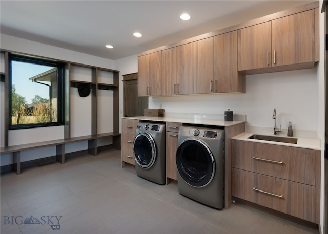 laundry area featuring cabinets, washing machine and clothes dryer, sink, and light tile patterned floors