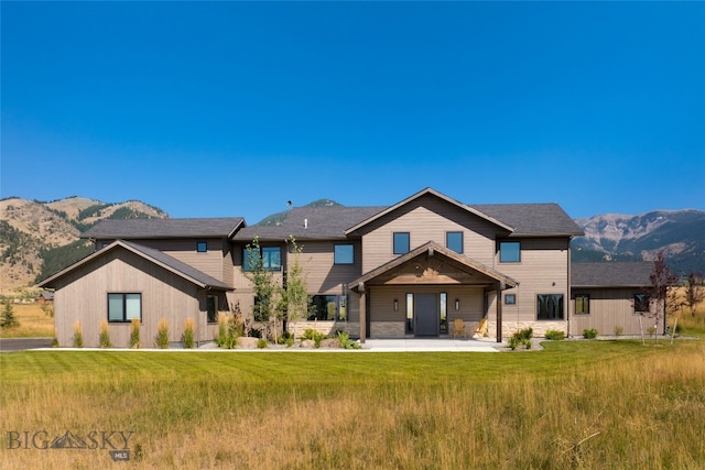 view of front of home with a mountain view, a patio, and a front yard