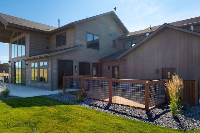 back of house with a patio area and a lawn