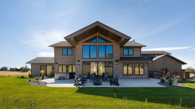 back of house with a yard, a hot tub, and a patio area