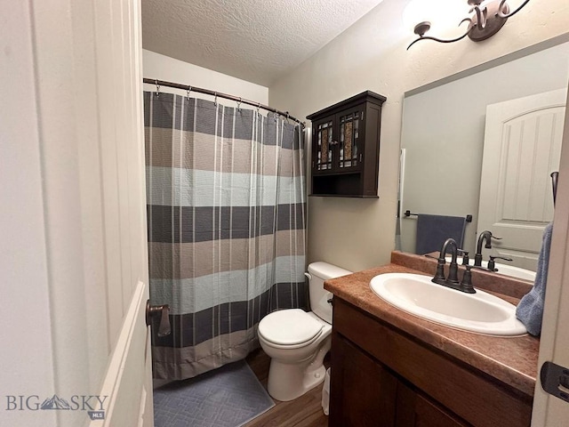 full bathroom featuring vanity, a shower with shower curtain, wood finished floors, a textured ceiling, and toilet